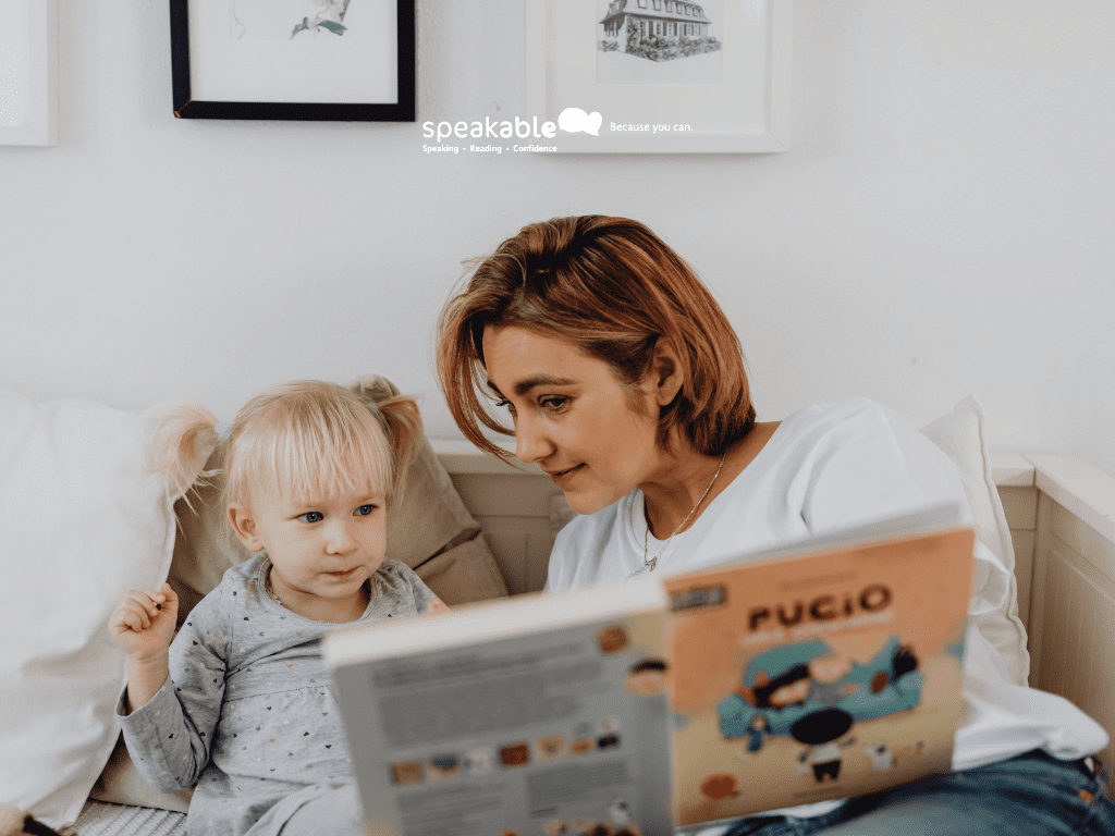Child engaging with a picture book while a parent supports conversation during reading.
