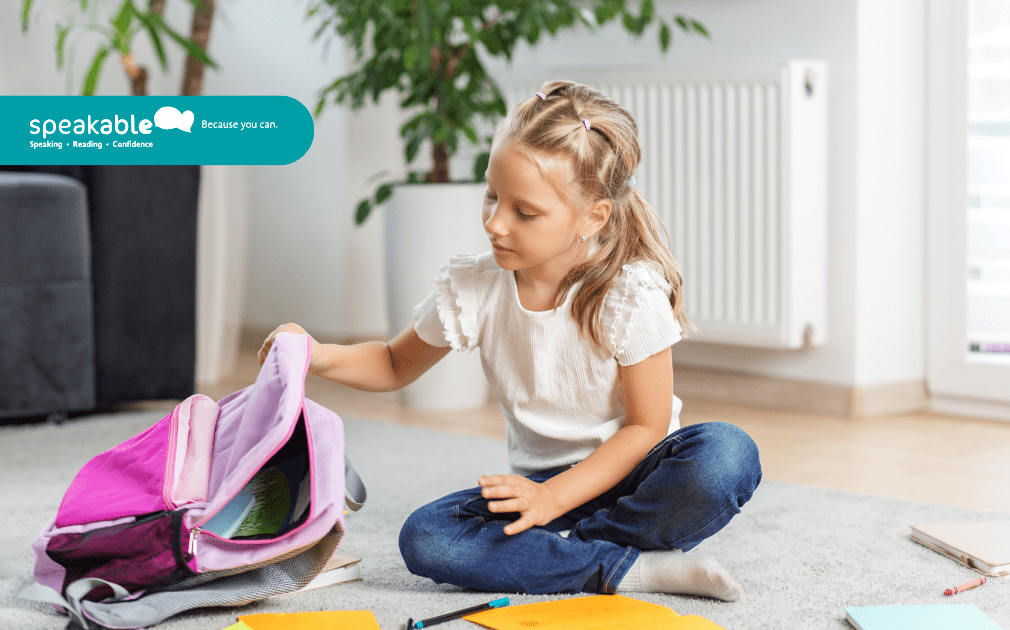 Child planning a school task while organising books and materials.