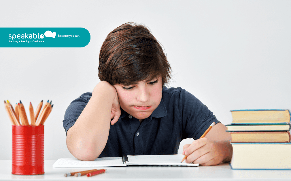 Child working on a writing task while receiving gentle support from an adult.