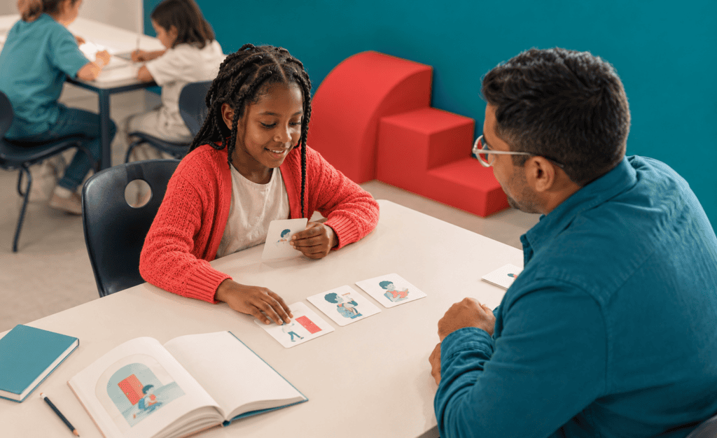 Teacher using visual support to help a child understand a classroom literacy task.